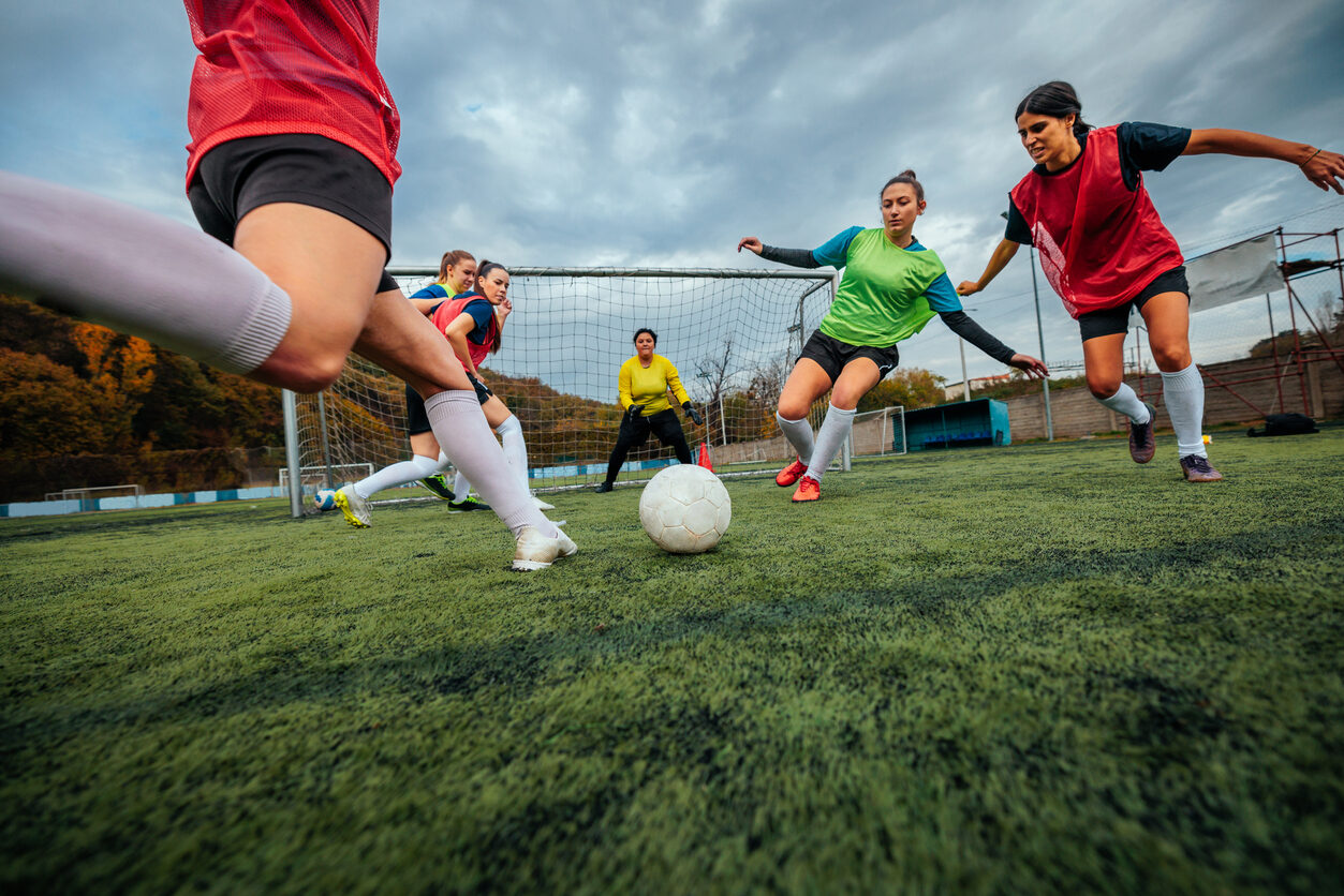 Closeup of female football player shooting at goal.